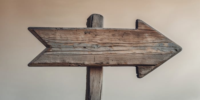 An old wooden sign pointing in the direction of the future photo