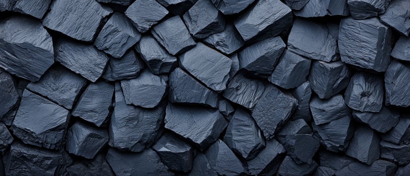 Black crushed rocks close up texture showing sharp, irregular shapes and rough surfaces. The dark stones create a rugged and natural pattern, emphasizing the raw, unpolished appearance. photo