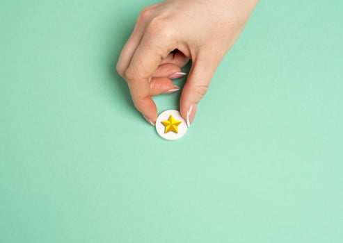 The hand holds a gold star. Distinction. Rating and recognition. Achievement. Top ratings in professional or educational settings. photo
