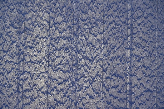 A waterfall runs down a blue wall in a striped design photo