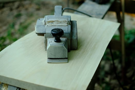 Electric hand planer on wood in vintage carpentry setting photo