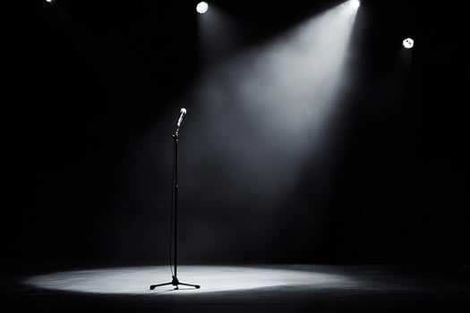 Microphone stands on empty stage awaiting performer under spotlights photo