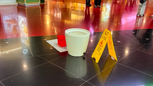Wet floor sign and bucket on a shiny mall floor, safety, maintenance concept, indoor cleaning March 16 2025, Barcelona, Spain photo