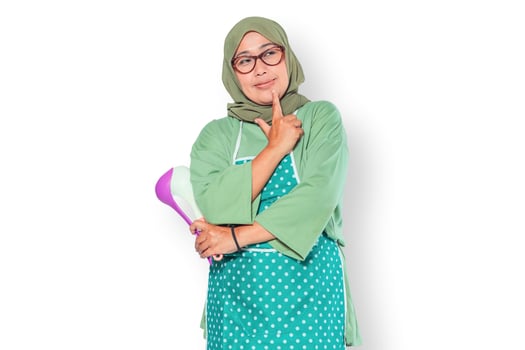 Thoughtful Muslim Woman Holding Kitchen Utensils photo
