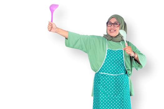 Happy Muslim Woman Cooking with Kitchen Utensils photo