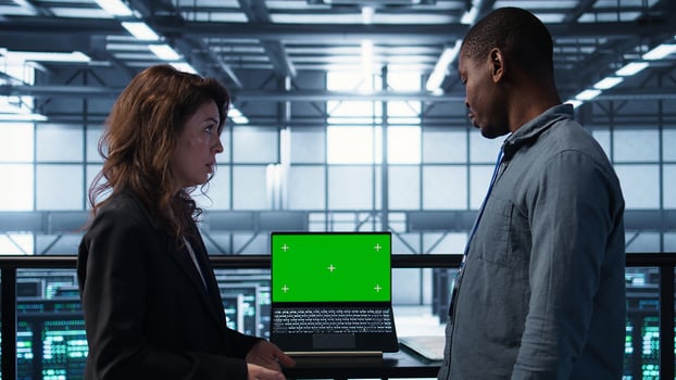 Team of computer scientists using mockup laptop to review equipment diagnostics. Teamworking IT experts adjusting server room configurations using chroma key notebook, camera B photo