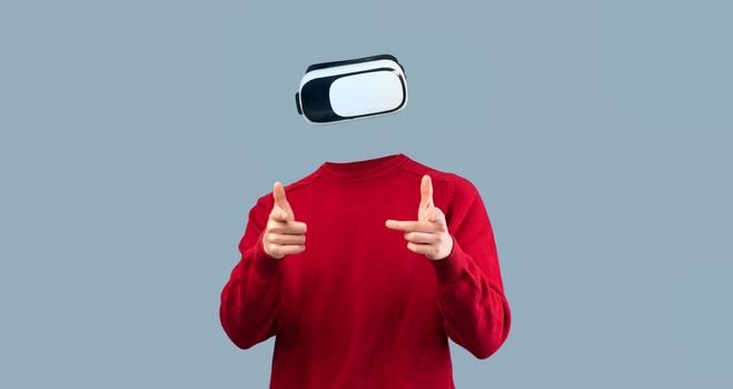 A person uses a virtual reality headset, indicating interaction with a digital environment. The individual is isolated against a neutral background, emphasizing the advanced technology involved. photo