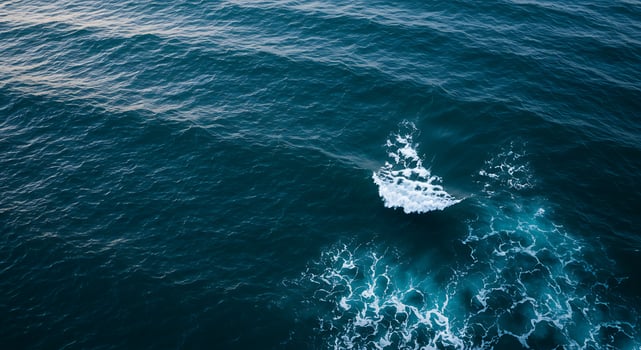 Ocean Wave Creating White Foamy Water and Deep Blue Sea Surface photo