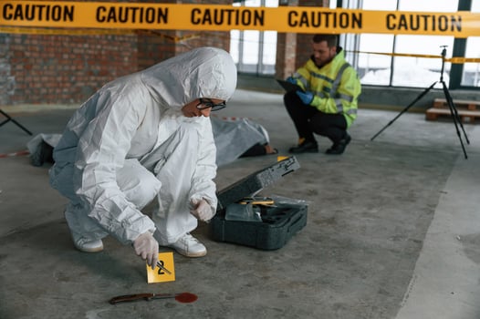 Knife as evidence.. Blood is on the floor. Detectives are in a crime scene near dead body photo