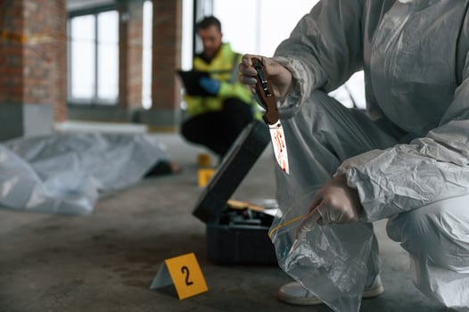 Putting ,the knife into bag. Detectives are collecting evidence in a crime scene near dead body photo
