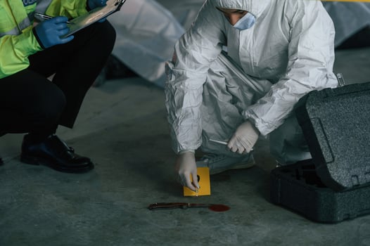 Detectives ,are collecting evidence, in a crime scene near dead body. Forensic specialists are making expertise photo