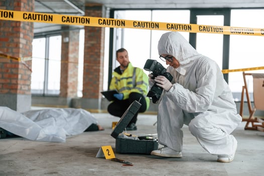 Knive ,,and blood is on the ground. Detectives are collecting evidence in a crime scene near dead body photo