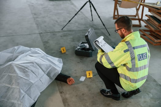 Notepad with information.. Male detective is collecting evidence in a crime scene near dead body on the construction site photo