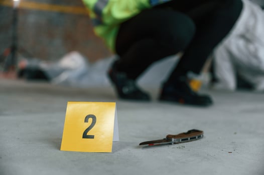 Detectives are collecting evidence in a crime scene near dead body. Forensic specialists are making expertise photo