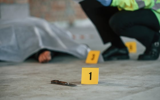 Male detective is, collecting ,evidence in a crime scene near dead body on the construction site photo
