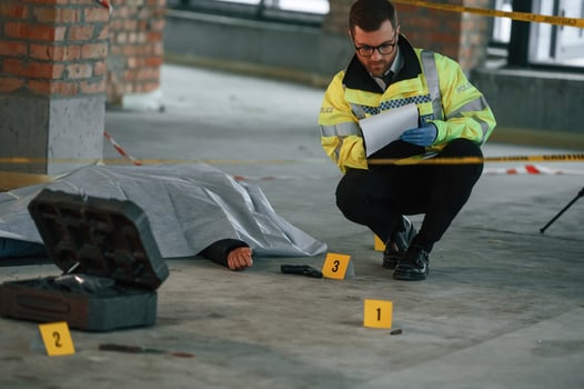 Notepad ,with, information.. Male detective is collecting evidence in a crime scene near dead body on the construction site photo