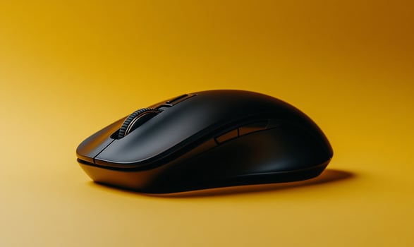 Sleek black wireless computer mouse on a vibrant yellow backdrop photo