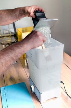 Man using a wash machine to clean a transparent 3d resin object, technology photo