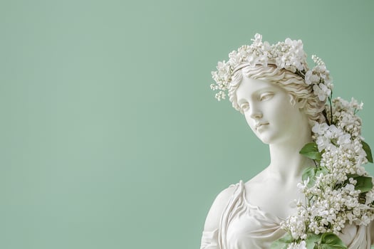 statue of a Greek goddess in a wreath of white flowers on a light green background photo