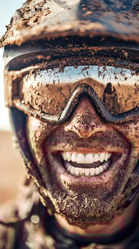 Close-up of a mud-covered motocross rider smiling with protective gear photo