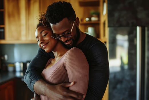 A young couple embracing in the kitchen photo
