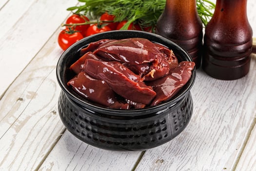 A bowl of meat and a bottle of beer photo