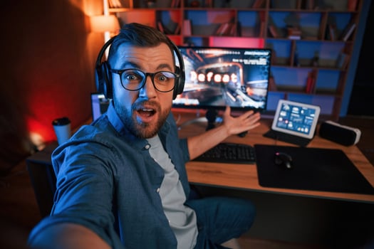 Man is playing the shooter,, game on his computer. Neon lighting photo