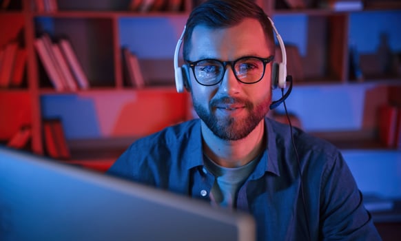 Read and ,blue neon lighting. Man is sitting by a computer indoors at home photo