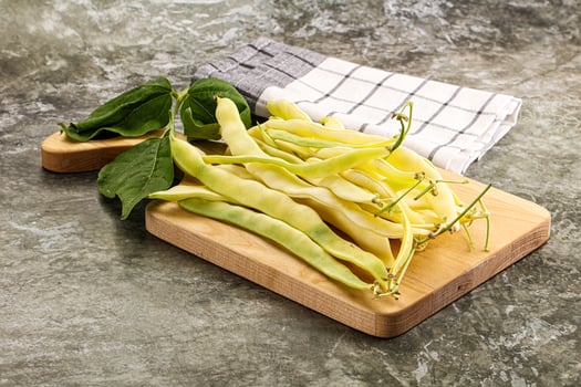A wooden cutting board with beans and a napkin photo