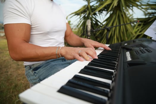 Boy Pianist Plays The Keyboard In An Outdoor Garden For Private Party photo