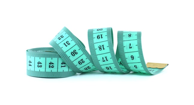 A light green measuring tape coiled on a white background, commonly used in sewing and tailoring. photo