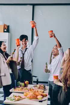 Group of young people celebrating with drinks and food photo