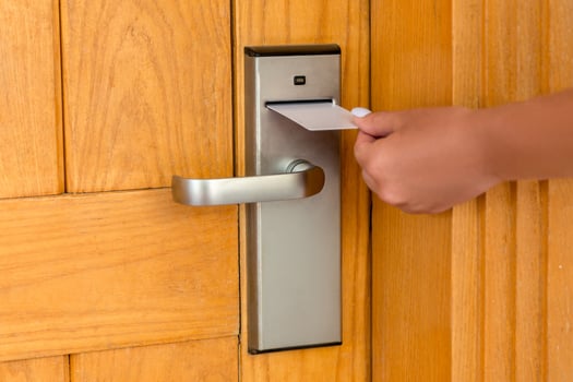 Female hand putting holding magnetic key card switch in to open hotel room door photo
