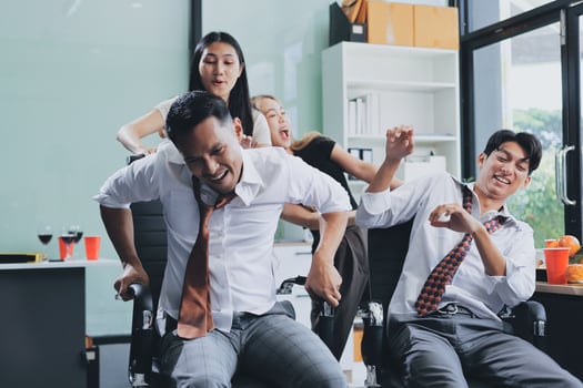 Three people in business attire are having fun in an office photo