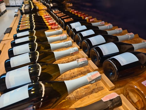 A variety of bottles of champagne are elegantly lined up on a wooden shelf photo