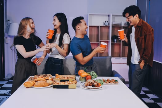 Four friends drinking coffee and eating food at a table photo