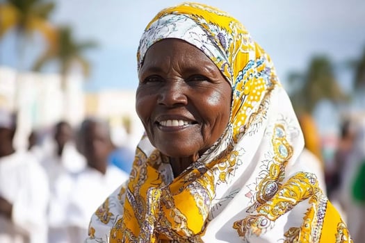 An older woman wearing a headscarf smiles for the camera photo