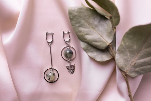 Female Jewelry. Vintage bijouterie jewelry. Beautiful handmade silver earrings on pink silk background. Flat lay, top view copy space and empty space for text photo