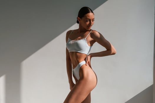 In, the studio, with beautiful sunlight. Young caucasian woman with slim body shape photo
