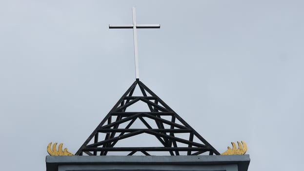 Symbol on the roof of the church, blue sky background. photo