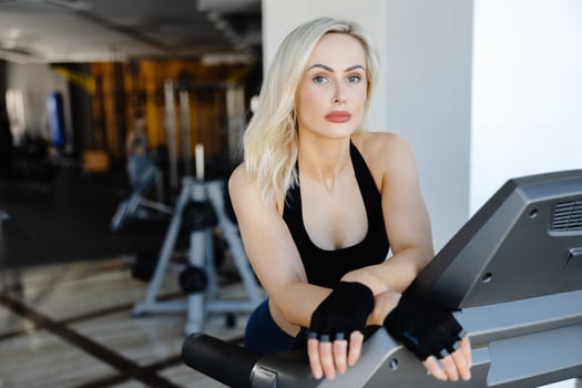 Determined sportswoman running on treadmill during fitness workout in gym photo