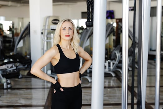 Woman wearing black sportswear posing in a gym photo