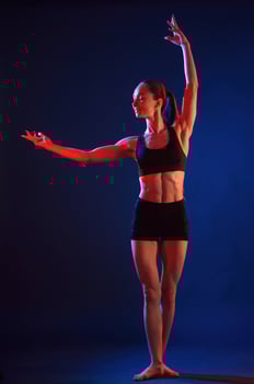 Standing, posing.. Beautiful, muscular woman is indoors in the studio with neon lighting photo