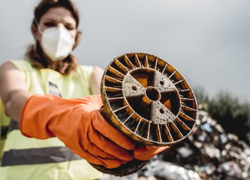 Woman volunteer helps clean the field of nuclear waste and plastic garbage. photo