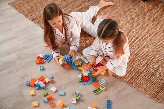View from the top. Playing ,construction game. Two ,little girls are having fun together in domestic room photo
