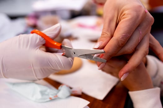 Female manicure process with hands clipping nails close up in salon setting photo