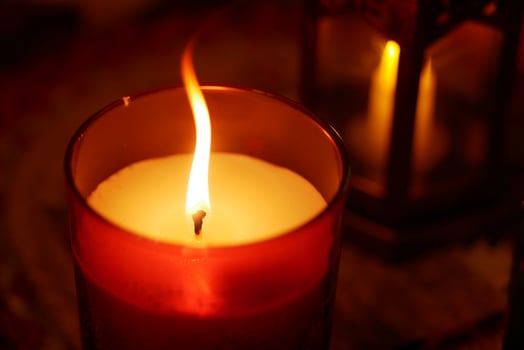 Candle flame glows softly in cozy indoor setting at night photo