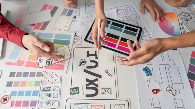UX Design and Collaboration. Creative professionals brainstorming UIUX concepts on a design table. photo