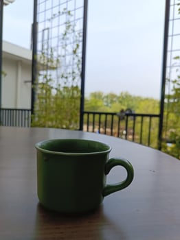 A green coffee cup sitting on a table photo