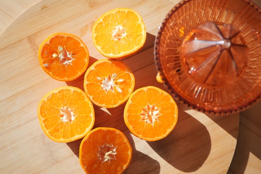 Fresh oranges sliced for juicing on wooden board in sunlight photo